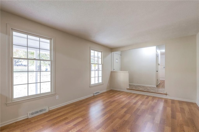 spare room featuring a textured ceiling and hardwood / wood-style flooring