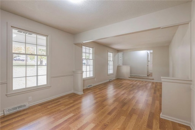 spare room featuring a textured ceiling and light wood-type flooring