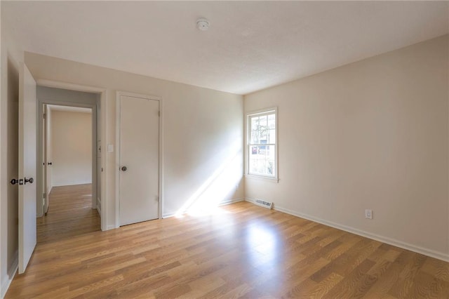 empty room with light hardwood / wood-style flooring