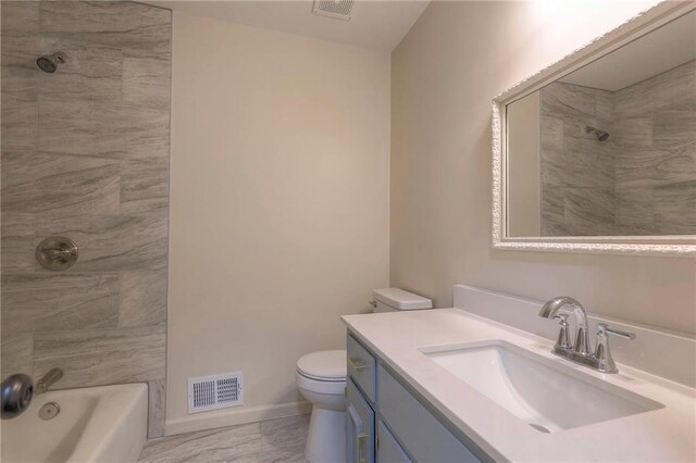 full bathroom with vanity, tiled shower / bath combo, and toilet