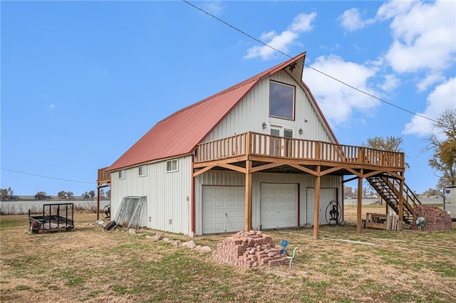 rear view of property with a wooden deck, a garage, and a lawn