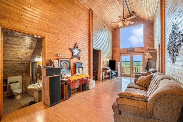 living room with wood ceiling, ceiling fan, high vaulted ceiling, and wooden walls