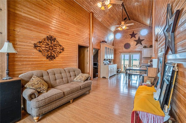 living room featuring hardwood / wood-style flooring, wooden walls, wooden ceiling, high vaulted ceiling, and ceiling fan