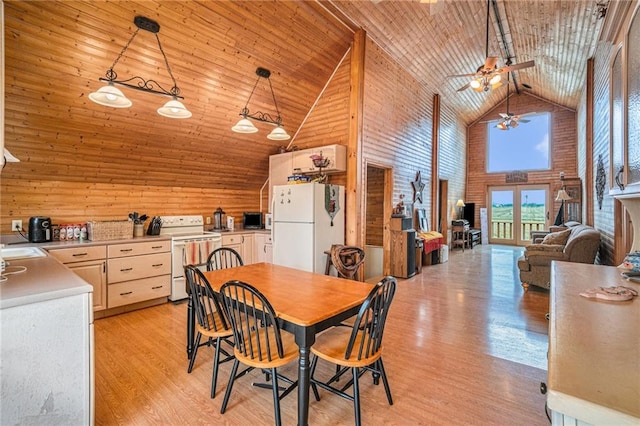 dining area with wood walls, wood ceiling, ceiling fan, light hardwood / wood-style floors, and high vaulted ceiling