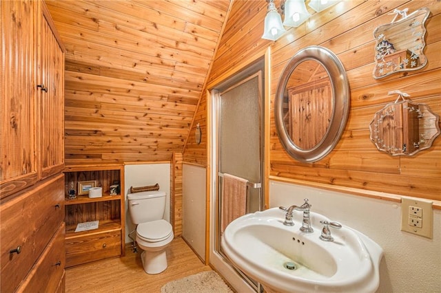 bathroom with toilet, hardwood / wood-style flooring, lofted ceiling, and wooden walls