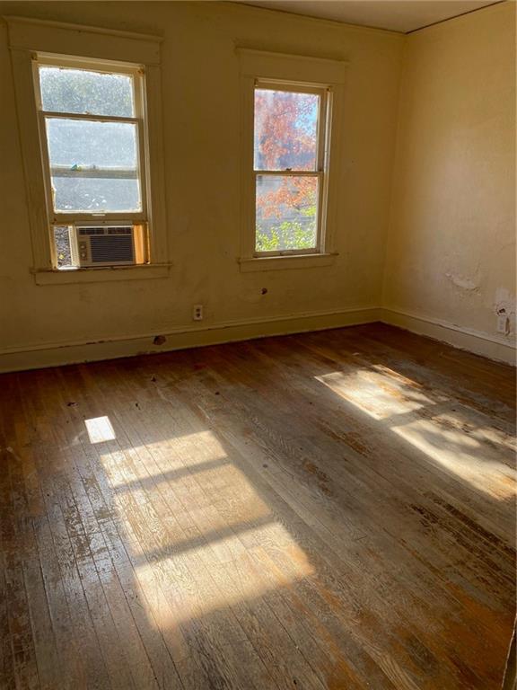 unfurnished room with wood-type flooring and cooling unit