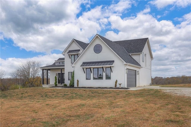 modern farmhouse featuring driveway, metal roof, a standing seam roof, covered porch, and a front yard