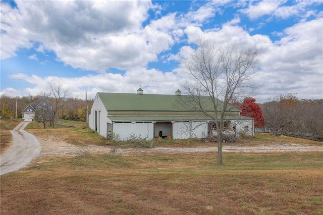 view of home's exterior with an outbuilding, driveway, a lawn, and an outdoor structure