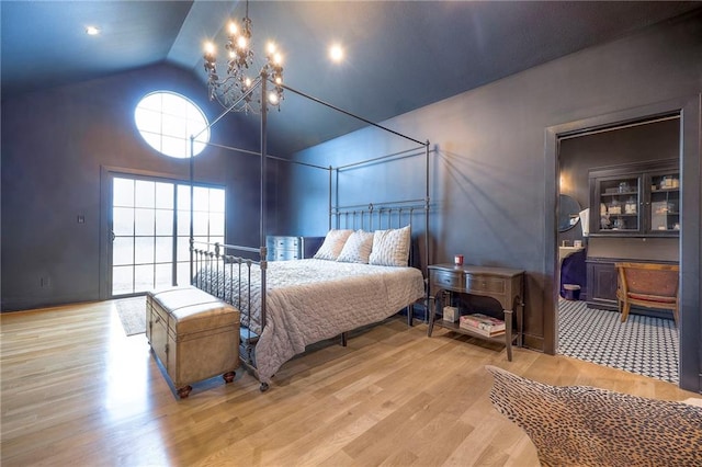 bedroom with lofted ceiling, light wood finished floors, and a chandelier