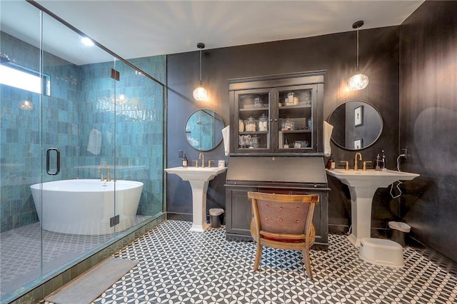 full bathroom featuring two sinks, a shower stall, and a freestanding bath