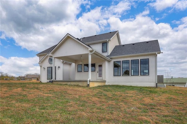 back of property featuring central AC unit and a lawn