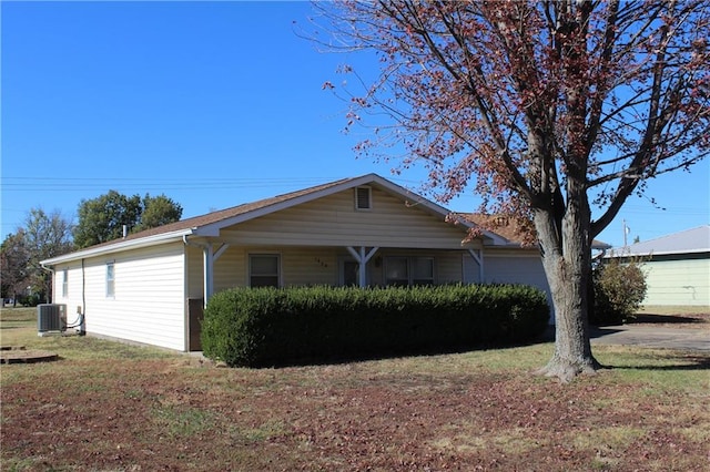 view of side of home with central air condition unit and a lawn