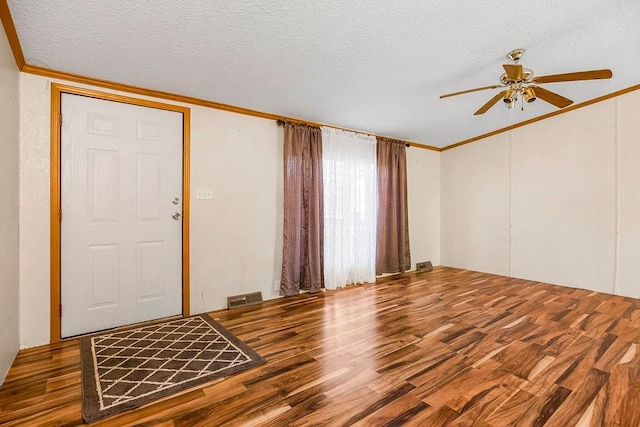 foyer entrance featuring hardwood / wood-style floors, crown molding, a textured ceiling, and ceiling fan