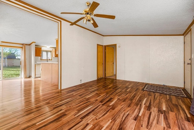 interior space featuring ornamental molding, light hardwood / wood-style flooring, a textured ceiling, and ceiling fan