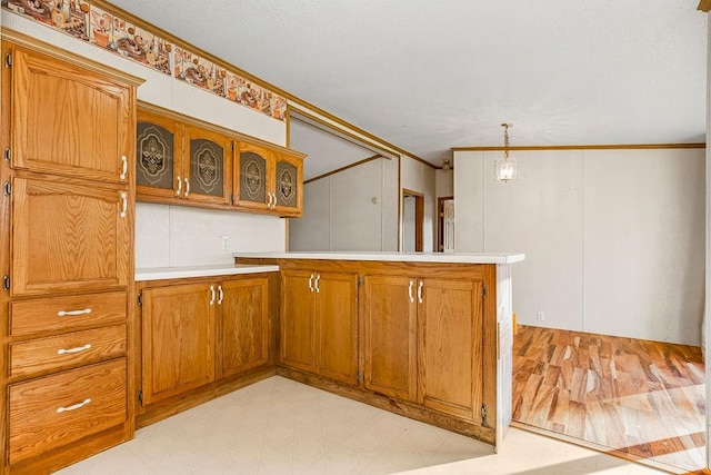 kitchen with kitchen peninsula, ornamental molding, and pendant lighting