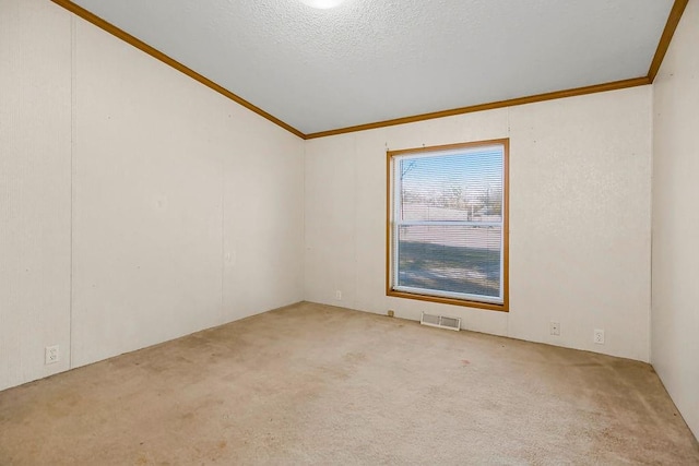 carpeted empty room featuring crown molding, a textured ceiling, and vaulted ceiling