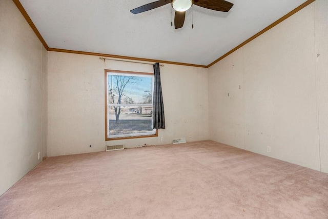 empty room with lofted ceiling, carpet, crown molding, and ceiling fan