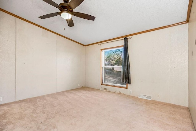 carpeted spare room featuring ornamental molding, a textured ceiling, and ceiling fan