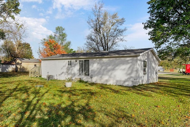 rear view of property with a lawn and central AC unit