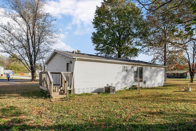 back of property with a yard and central air condition unit