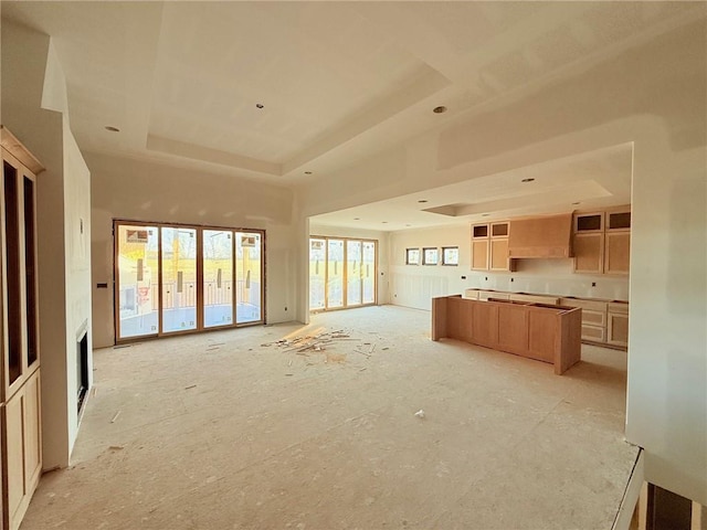 unfurnished living room with a raised ceiling