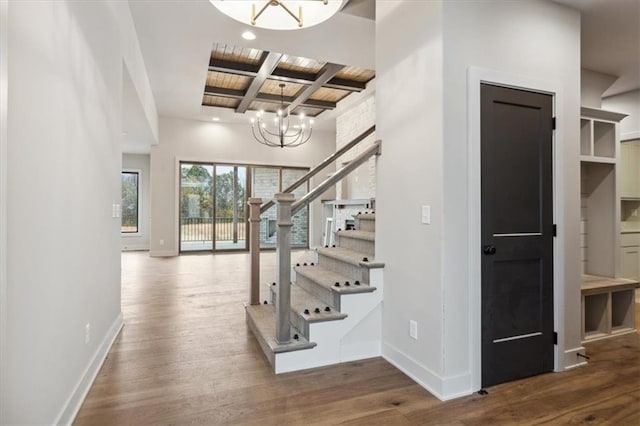 stairs featuring an inviting chandelier, hardwood / wood-style floors, beamed ceiling, and coffered ceiling