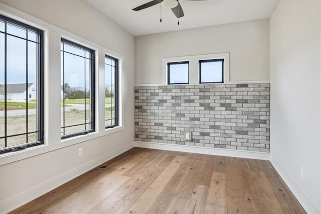 empty room featuring light hardwood / wood-style floors, a healthy amount of sunlight, and ceiling fan