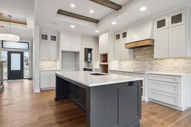 kitchen with white cabinetry, light hardwood / wood-style floors, and a center island