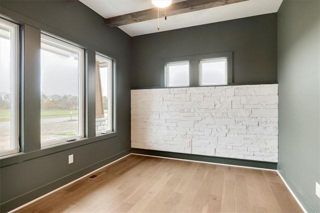 unfurnished room featuring ceiling fan, beamed ceiling, and light wood-type flooring