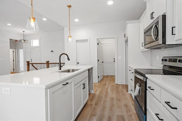 kitchen featuring sink, a kitchen island with sink, decorative light fixtures, and stainless steel appliances