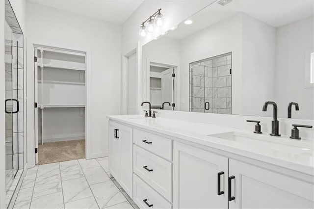 bathroom featuring a shower with door and vanity