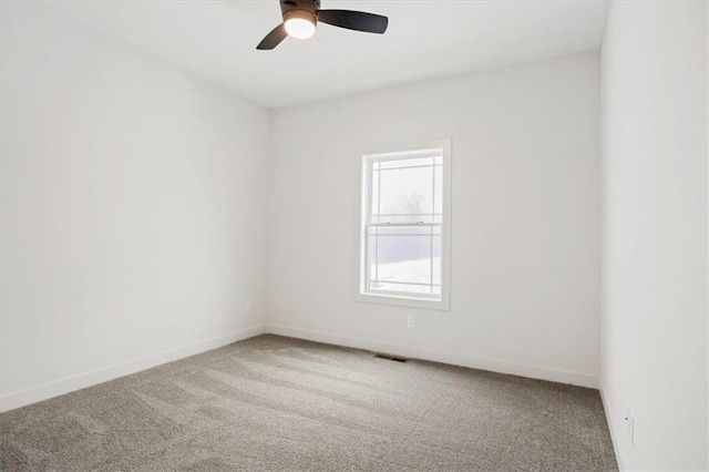 carpeted spare room with ceiling fan