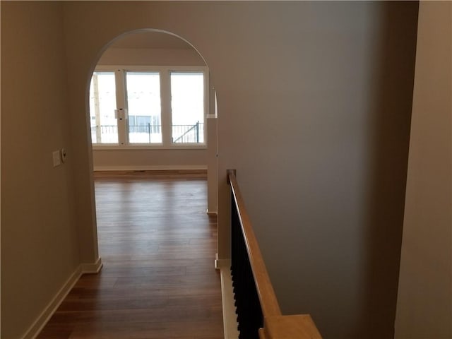 hall with dark wood-type flooring and baseboards