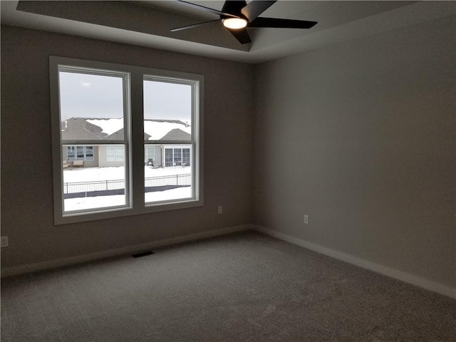 unfurnished room with ceiling fan, visible vents, baseboards, and carpet flooring