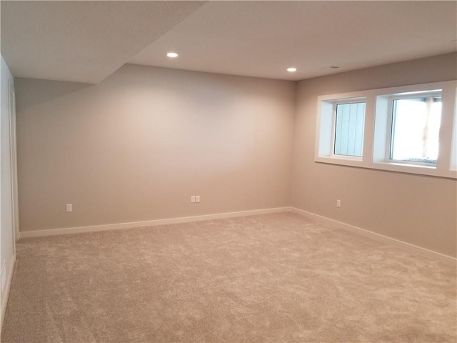 empty room featuring recessed lighting, baseboards, and light colored carpet