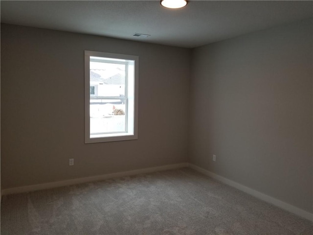 spare room with baseboards, visible vents, and carpet flooring