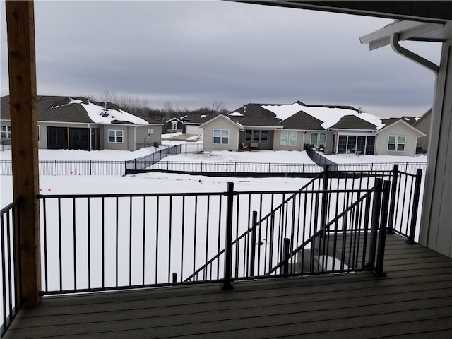 snow covered deck with fence private yard and a residential view