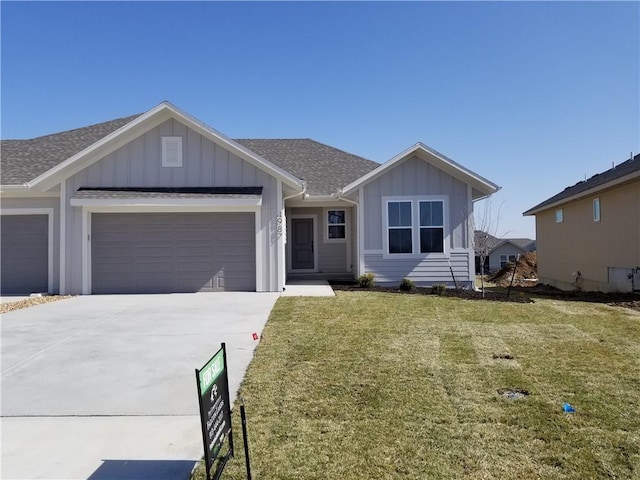 single story home featuring a shingled roof, concrete driveway, an attached garage, board and batten siding, and a front yard