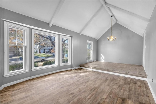 unfurnished living room featuring vaulted ceiling with beams, wood-type flooring, and a chandelier