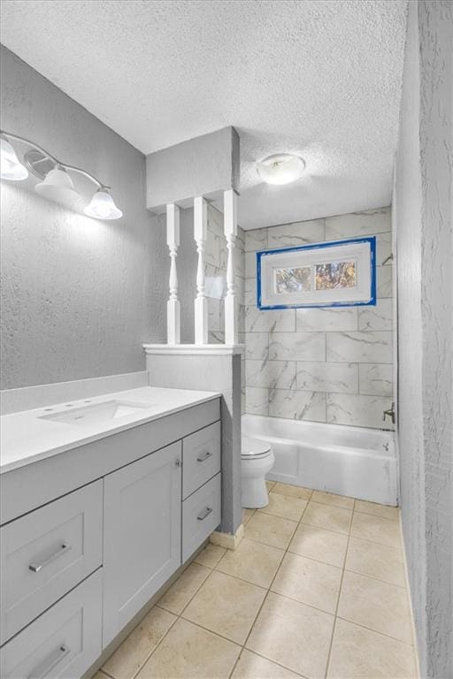 full bathroom featuring tile patterned floors, vanity, a textured ceiling, toilet, and tiled shower / bath