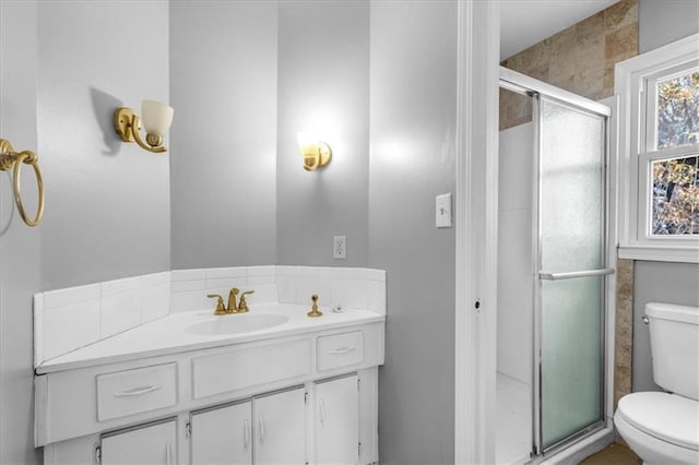 bathroom featuring vanity, toilet, and walk in shower