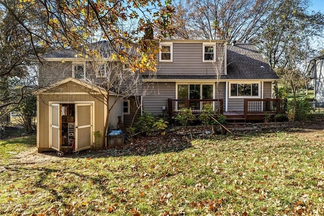 rear view of house featuring a lawn, a wooden deck, and a shed