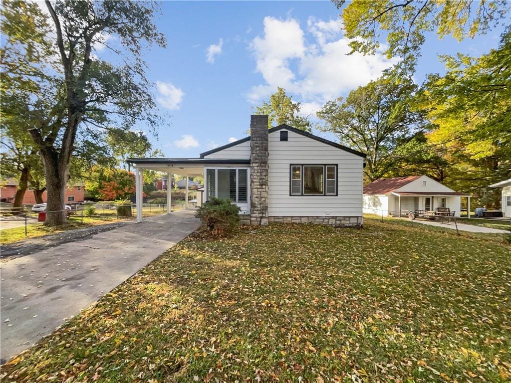 view of front of home with a carport and a front lawn