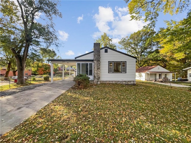 view of front of home with a carport and a front lawn