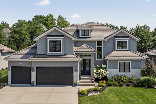 view of front of house with french doors, a front lawn, and a garage