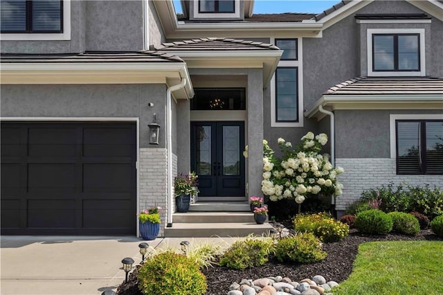 view of exterior entry with french doors and a garage