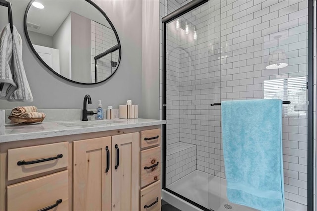 bathroom featuring vanity and a shower with shower door