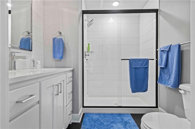 bathroom with walk in shower, tile patterned floors, vanity, and toilet