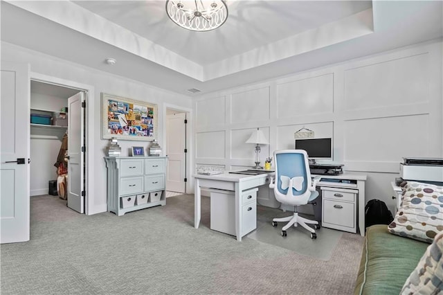 carpeted office space featuring a raised ceiling