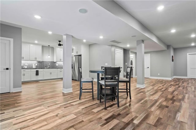 dining area with light wood-type flooring, ceiling fan, and sink